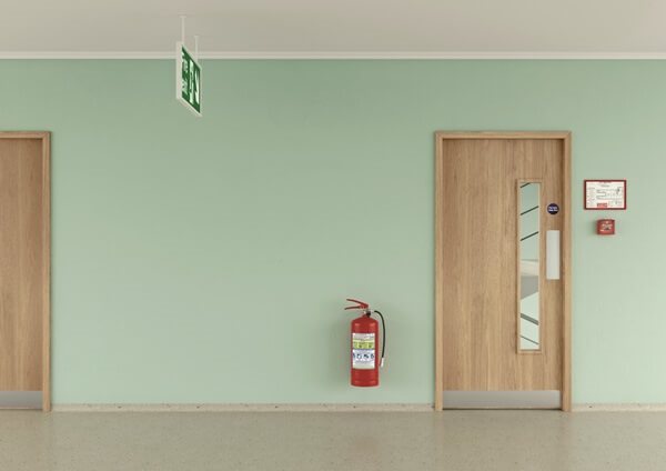 A woodgrain communal internal doorset with a glass insert, on a corridor with green walls.